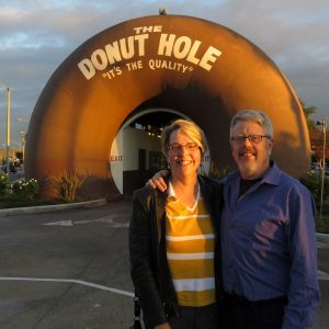 Smiling couple in front of giant donut