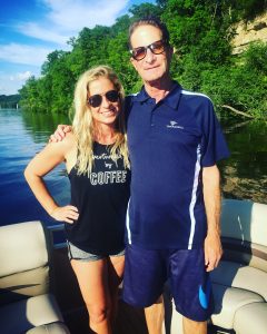 Father and daughter smiling on boat while on the water.
