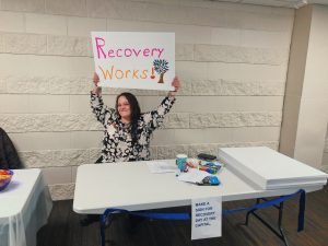 Woman holding sign that says Recovery Works.