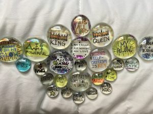 Collection of glass stones with positive messages written on them
