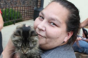 Woman holding a gray tabby cat